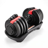 Adjustable dumbbell in black with red locking levers and dial weight selector, seated in its cradle base on a white background