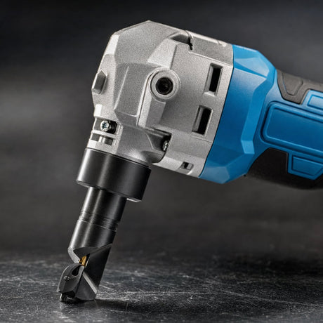 Close up of metal nibbler cutting head punch and die with cast metal gearbox housing