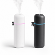 Mini car aroma diffuser in matte white and matte black with glowing LED rings and vent clips, on white background