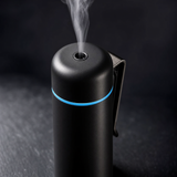 Close up of black mini aroma diffuser mist nozzle, blue LED ring and metal vent clip