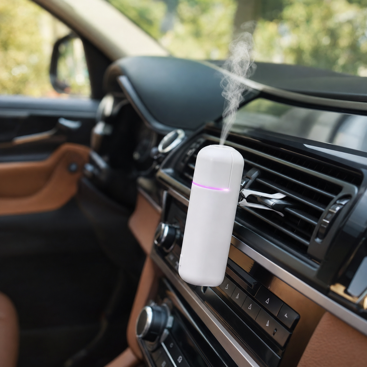 White mini aroma diffuser clipped to a car air vent releasing fragrance mist