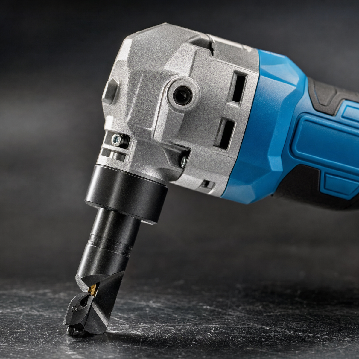 Close up of metal nibbler cutting head punch and die with cast metal gearbox housing