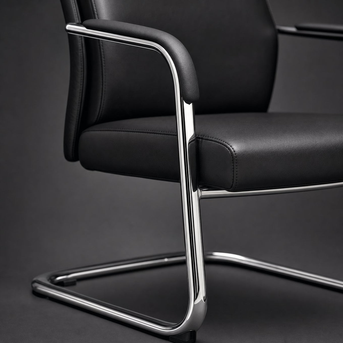 Close up of conference chair padded armrest, stitched black upholstery and polished chrome cantilever frame