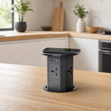 Pop up socket installed flush in a kitchen island worktop, raised with a smartphone charging on top