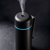 Close up of black mini aroma diffuser mist nozzle, blue LED ring and metal vent clip